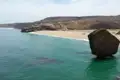 Strand mit Felsen und türkisfarbenem Wasser.
