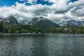 Ansicht eines Bergsees mit einem Hotel am Ufer und Bergen im Hintergrund.