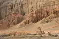 Alte Stupa vor einer imposanten Felswand.