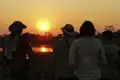 Reisegruppe beim Beobachten des Sonnenuntergangs.