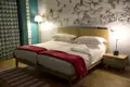 Zwei Einzelbetten in einem Schlafzimmer mit Vogelmotiv an der Wand.