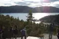 Wanderer auf einem Aussichtspunkt mit Blick auf eine Bucht und eine Fähre.