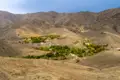 Blick auf ein abgelegenes Bergdorf in einer trockenen Landschaft.