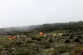 Basislager mit Zelten in nebliger Berglandschaft.