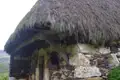Reetdach und Steinmauerwerk einer historischen Hütte.