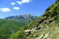 Wanderer auf einem Bergpfad inmitten einer Berglandschaft.