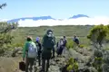 Wandergruppe auf einem Bergpfad mit Blick auf die Berge im Hintergrund.