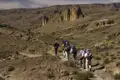 Wanderer auf einem Pfad in einer wüstenartigen Landschaft.