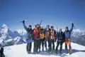 Bergsteigerteam auf dem Gipfel eines schneebedeckten Berges.