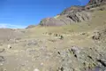 Wandergruppe auf einem Bergpfad in felsiger Landschaft.