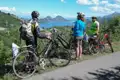 Drei Radfahrer mit Helmen und Fahrrädern halten an und betrachten die Bucht während ihrer Radreise.