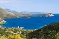 Radreise Albanien Blick auf albanische Riviera. Panorama der Küstenlandschaft mit tiefblauem Wasser, Bergen und einer kleinen Insel.