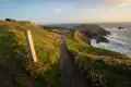 Wegweiser auf einem Küstenwanderweg mit Blick auf das Meer.
