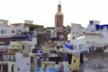 Traditionelle marokkanische Architektur mit Flachdächern und einem Minarett, das die Skyline dominiert.