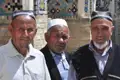 Drei Männer in traditioneller Kleidung, möglicherweise während einer kulturellen Begegnung auf der Reise.
