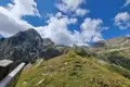 Alpenlandschaft mit Bergen und bewölktem Himmel.