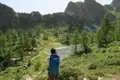 Wanderer fotografiert Bergsee inmitten einer alpinen Landschaft.