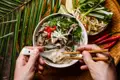 Eine Person isst eine Schüssel Pho, eine vietnamesische Nudelsuppe.