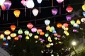 Bunte Laternen beleuchten eine Straße bei Nacht.