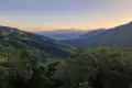 Sonnenuntergang über einem bewaldeten Tal und Bergen.