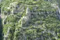Gewundener Bergpfad durch Felsen und Vegetation.
