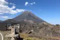 Willkommensschild am Eingang zum Parque Natural do Fogo mit dem Vulkankegel im Hintergrund.