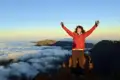 Wanderer genießt den Ausblick vom Berggipfel über den Wolken.