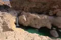 Wasserfall in felsiger Schlucht mit türkisfarbenem Becken.