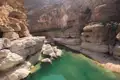 Türkisfarbener Fluss in einer felsigen Schlucht.
