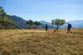 Zwei Wanderer mit Rucksäcken auf einer Wanderung durch eine trockene, bergige Landschaft.