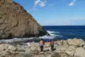 Zwei Wanderer an der Küste mit Blick auf das Meer.