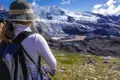 Wanderin bewundert die Aussicht auf einen Gletscher und die darunterliegenden Seen.