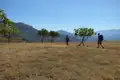 Zwei Wanderer mit Rucksäcken auf einer Wanderung durch eine trockene Landschaft.