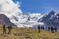 Wandergruppe in den Bergen vor schneebedecktem Gipfel.