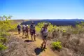 Wanderer auf einem Pfad in der Nähe eines Lavafeldes.