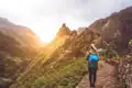 Wanderer auf einem Bergpfad im Sonnenuntergang.