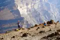Wanderer am Rande eines tiefen Canyons mit Blick auf die Landschaft.