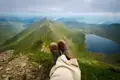 Aussicht vom Gipfel auf einen Bergsee und die umliegende Berglandschaft.