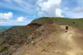 Wanderer auf einem Bergpfad mit Blick auf die umliegende Landschaft.