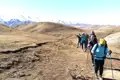 Wandergruppe auf einem Bergpfad mit Blick auf die schneebedeckten Gipfel.