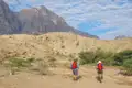 Zwei Wanderer auf einer Trekkingtour in einer bergigen Wüstenlandschaft.