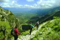 Wanderer auf einem Bergpfad mit Blick auf ein Tal.