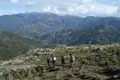 Wanderer mit Rucksäcken auf einem Bergpfad mit Blick auf die Bergkette.