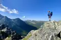 Wanderer auf einem Berggipfel mit Blick auf das Tal.