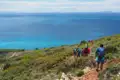 Wandergruppe auf einem Küstenpfad mit Blick auf das Meer.