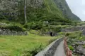 Wanderweg mit Wasserfall und Steinmauern