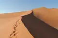 Fußabdrücke im Sand einer Düne.