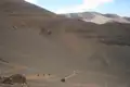 Wanderer auf einem Bergpfad in einer trockenen, bergigen Landschaft.