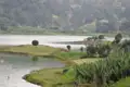 Panoramablick auf einen See mit Inseln, Bäumen und landwirtschaftlich genutzten Flächen, umgeben von Hügeln.