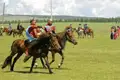 Junge Reiter in traditioneller Kleidung beim Pferderennen.